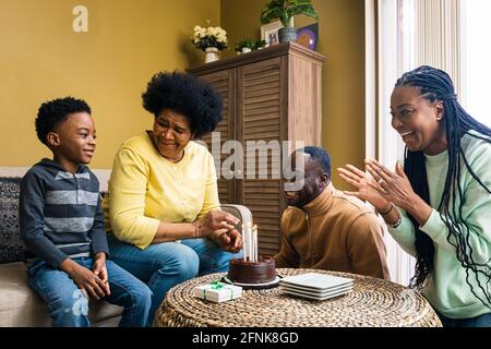 Fröhliche, generationsübergreifende Familie, die zu Hause Geburtstag feiert Stockfoto