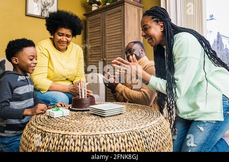 Glückliche, generationenübergreifende Familie, die zu Hause gemeinsam Geburtstag feiert Stockfoto