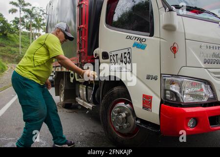 Dosquebradas, Risaralda, Kolumbien. Mai 2021. Ein an der Blockade teilnehmender Trucker wäscht seinen Lastwagen, als nationale Trucker am 17. Mai 2021 in Dosquebradas, Santa Rosa de Cabal Verkehrskreis Risaralda, Kolumbien, streiken. Im Rahmen der Anti-Regierung-Proteste in Kolumbien, die in 20 Tagen Demonstration gegen Polizeibrutalität und Gesundheits- und Steuerreformen von Präsident Ivan Duque mindestens 40 Tote geführt haben. Quelle: Sebastian Osorio/LongVisual/ZUMA Wire/Alamy Live News Stockfoto