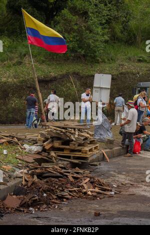 Dosquebradas, Risaralda, Kolumbien. Mai 2021. Eine kolumbianische Flagge wird über einem LKW-Blockadecamp hochgehoben, als nationale Trucker am 17. Mai 2021 in Dosquebradas, Santa Rosa de Cabal, den Verkehrskreis Risaralda, Kolumbien, streiken. Im Rahmen der Anti-Regierung-Proteste in Kolumbien, die in 20 Tagen Demonstration gegen Polizeibrutalität und Gesundheits- und Steuerreformen von Präsident Ivan Duque mindestens 40 Tote geführt haben. Quelle: Sebastian Osorio/LongVisual/ZUMA Wire/Alamy Live News Stockfoto