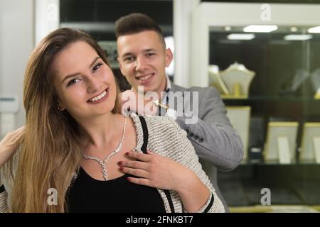 Attraktives junges Paar, das die Auswahl der Halskette beim Schmuck prüft Speichern Stockfoto