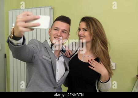 Porträt eines glücklichen jungen romantischen Paares in der Liebe in Luxus-Shop und Selfies mit dem Mobiltelefon Stockfoto