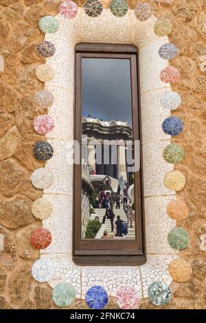 Spiegelung der Drachentreppe und Säulen des Hypostyle-Raumes im Fenster der Casa del Guarda im Park Güell, Barcelona, Spanien Stockfoto