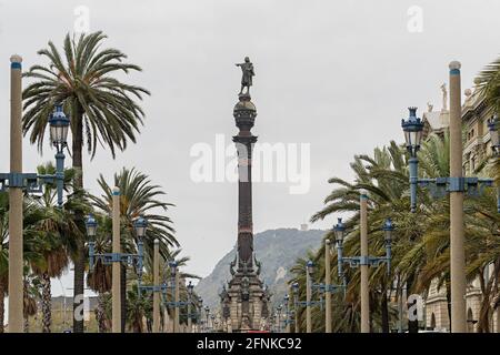 Blick auf das Kolumbus-Denkmal von der von Palmen gesäumten Passeig de Colom Straße, Barcelona, Spanien Stockfoto