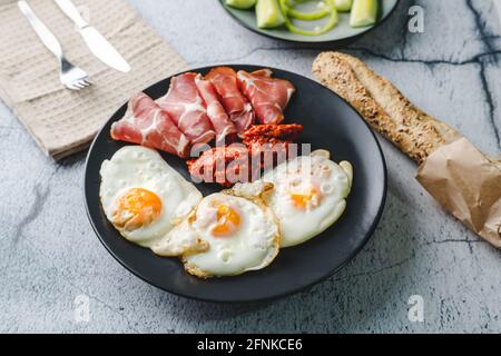 Blick von oben auf die sonnige Seite Eier Prosciutto coppa Capocollo trockenes Fleisch und hausgemachten Ajvar Paprikasalat auf der Tisch als Abendessen oder Frühstück Stockfoto