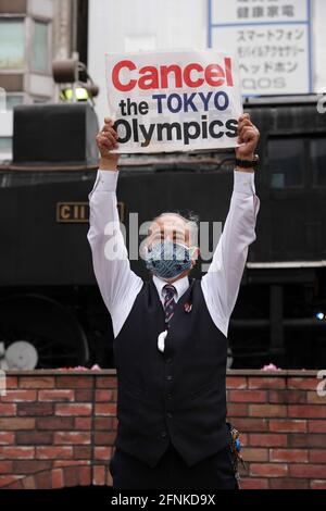 Tokio, Japan. Mai 2021. Ein Protestler, der eine Gesichtsmaske trägt, hält ein Schild mit der Aufschrift "Cancel the Tokyo Olympics" während einer gegen Tokio gerichteten Olympischen Spiele-Kundgebung 2020 vor dem Shinbashi-Bahnhof hoch.rund 30 bis 40 Demonstranten gingen auf die Straße und forderten die Absage der Olympischen Spiele in diesem Sommer. Sie wurden von der gleichen Anzahl von Polizisten begleitet. Die Demonstranten gingen vom Bahnhof Shinbashi durch den Bezirk Ginza zum Hauptbüro des Organisationskomitees für die Spiele. Kredit: SOPA Images Limited/Alamy Live Nachrichten Stockfoto