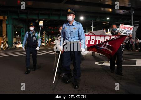 Tokio, Japan. Mai 2021. Während einer Kundgebung gegen die Olympischen Spiele 2020 in Tokio im Stadtteil Ginza gehen Polizisten den Weg für die Demonstranten.rund 30 bis 40 Demonstranten gingen auf die Straße und forderten die Absage der Olympischen Spiele in diesem Sommer. Sie wurden von der gleichen Anzahl von Polizisten begleitet. Die Demonstranten gingen vom Bahnhof Shinbashi durch den Bezirk Ginza zum Hauptbüro des Organisationskomitees für die Spiele. Kredit: SOPA Images Limited/Alamy Live Nachrichten Stockfoto