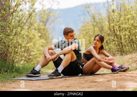 Fit Mann und Frau ruhen sich nach dem Fitnesstraining im Freien aus. Stockfoto