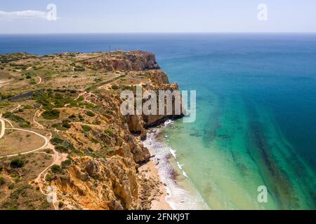 Canavial Beach in Lagos, Algarve - Portugal. Portugiesische südliche goldene Küstenklippen. Luftaufnahme mit sonnigem Tag. Ponta da Piedade im Hintergrund. Stockfoto