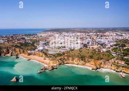 Camilo Beach in Lagos, Algarve - Portugal. Portugiesische südliche goldene Küstenklippen. Luftaufnahme mit der Stadt im Hintergrund. Dona Ana Strand und Hotel. Stockfoto