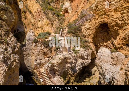 'Ponta da Piedade' - portugiesische goldene Küstenklippen im Süden. Luftaufnahme über die Stadt Lagos an der Algarve, Portugal. Türkisfarbenes Meer. Treppen und Grotte. Stockfoto