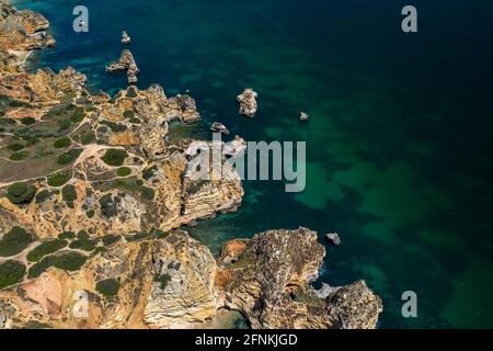 'Ponta da Piedade' - portugiesische goldene Küstenklippen im Süden. Luftaufnahme über die Stadt Lagos an der Algarve, Portugal. Stockfoto