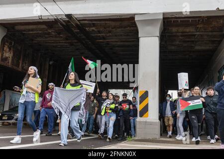 Dayton, Usa. Mai 2021. Die Demonstranten marschieren unter einer Überführung mit traditionellen palästinensischen Keffiyeh-Tüchern und palästinensischen Fahnen. Demonstranten treffen sich auf dem Courthouse Square in Dayton, Ohio, um sich zu versammeln und gegen den israelischen Luftangriff auf Gaza und die Besetzung Palästinas zu marschieren. Nach Angaben des von der Hamas geführten Gesundheitsministeriums beträgt die Gesamtzahl der Todesopfer rund 200, darunter 59 Kinder und 35 Frauen, wobei mindestens 1,305 verletzt wurden. (Foto von Stephen Zenner/SOPA Images/Sipa USA) Quelle: SIPA USA/Alamy Live News Stockfoto