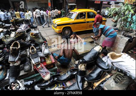 20.02.2011, Kalkutta, Westbengalen, Indien, Asien - EINE Gruppe von Männern, die ein traditionelles longyi tragen, wäscht sich an einem öffentlichen Wasserhahn auf der Straße. Stockfoto