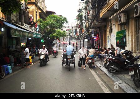 Vietnamesen reiten Radfahren fahren und ausländische Reisende zu Fuß reisen Besuchen Sie die Altstadt und kaufen Sie lokale Produkte in Hanoi 36 ein Straßen Altstadt Stockfoto