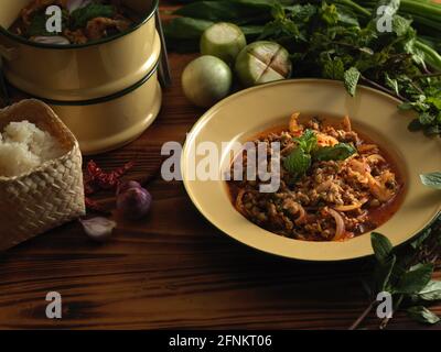 Nahaufnahme der traditionellen thailändischen Küche, würziger Schweinesalat (Larb Moo), serviert mit Gemüse und klebrigem Reis Stockfoto
