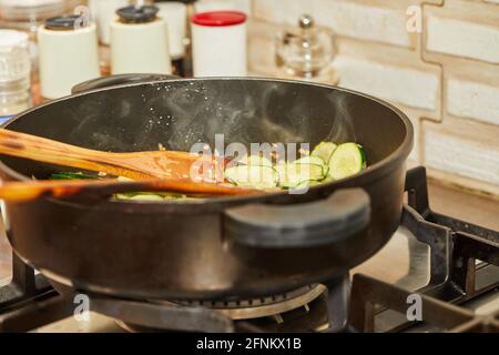 Gebratene Zucchini mit Zwiebeln in der Pfanne, zum Gratinieren mit Blauschimmelkäse, Schritt-für-Schritt-Rezept aus dem Internet. Stockfoto