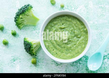 Babynahrung. Grünes Brokkoli-Püree aus biologischem Anbau mit Zutaten. Brokkoli und Erbsen püriert Stockfoto
