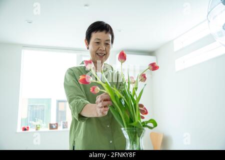 Frau, die Vermittlung von Blumen Stockfoto