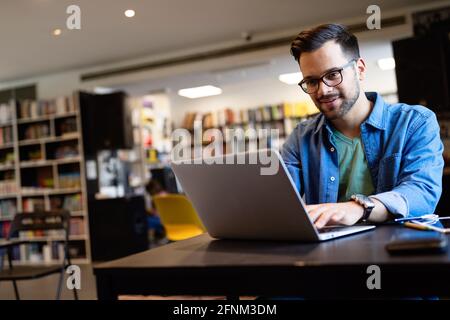 Der Schüler bereitet die Prüfung und den Lernunterricht in der Schulbibliothek vor Stockfoto