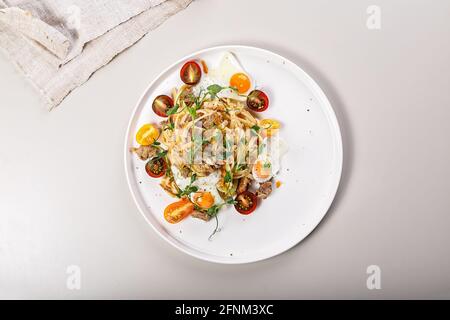 Köstliches mediterranes Mittag- oder Abendessen. Köstliche hausgemachte Spaghetti mit Gemüse, Käse und gebratenen Wachteleiern. Traditionelle italienische Küche. Stockfoto