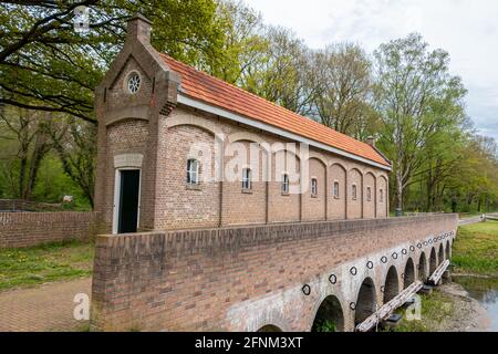 Das alte Wehr mit dem Namen 'schuivenhuisje', das 1887 auf dem Kanal Almelo-Nordhorn in der Provinz Overijssel, Niederlande, erbaut wurde Stockfoto