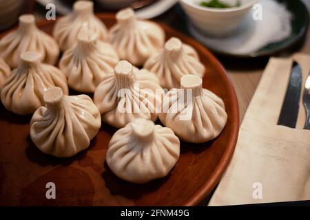 Khinkali ist ein Gericht der georgischen Küche. Essen auf einem Teller. Gekochter Teig mit Füllung. Knödel. Das Mittagessen steht auf dem Tisch. Ein Teil von khinkali in der Stockfoto