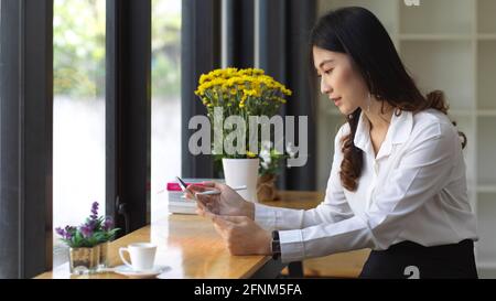 Seitenansicht einer Studentin mit digitalem Tablet Beim Sitzen im Café Stockfoto