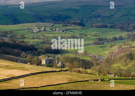Landschaftlich reizvolle Aussicht auf Wharfedale (breites grünes Tal, sanfte Hügel, hohe Hochlandfells, sonnenbeschienene Barden Tower Ruinen) - Yorkshire Dales, England, Großbritannien. Stockfoto