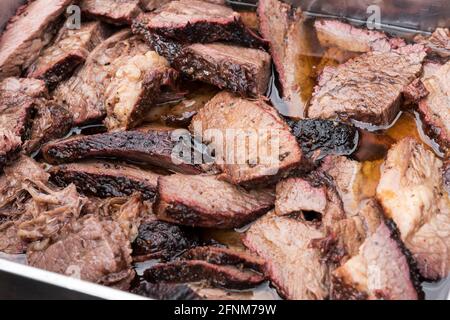 In Scheiben geschnittenes und gewürfeltes, zartes, mageres Roastbeef brisket Fleischsäfte auf einem Metalltablett auf einem Buffet In einer Nahaufnahme im Vollformat Stockfoto