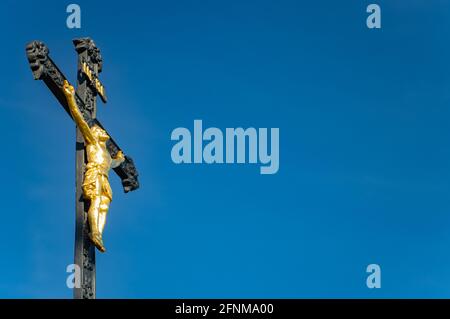 Ein eisernes Kreuz mit dem gekreuzigten Jesus Christus auf einem Hintergrund des blauen Himmels Stockfoto