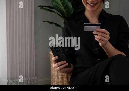 Asiatische Mädchen, die Online-Zahlung mit dem Smartphone für den Einkauf zu Hause. Stockfoto