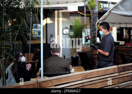 (210518) -- SAN MATEO, 18. Mai 2021 (Xinhua) -- EIN Mitarbeiter, der eine Maske trägt, bedient die Kunden in einem Restaurant in San Mateo, Kalifornien, USA, 17. Mai 2021. Kaliforniens Gesundheitsbeamte sagten am Montag, dass der bevölkerungsreichste Staat der Vereinigten Staaten vor dem 15. Juni nicht „die CDC-Richtlinien umsetzen würde, die es vollständig geimpften Menschen ermöglichen, in den meisten Situationen ohne Maske zu gehen“. Letzte Woche sagten die US-amerikanischen Zentren für die Kontrolle und Prävention von Krankheiten (CDC), dass es für vollständig geimpfte Menschen sicher sei, gesichtsbedeckungen und soziale Distanzierungen in den meisten Situationen zu überspringen, wie es in vielen Staaten der Fall ist Stockfoto