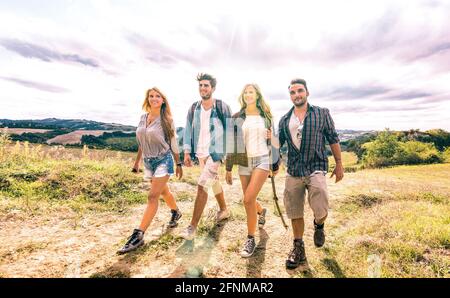 Beste Freunde Gruppe zu Fuß frei auf Gras Wiese - Freundschaft Und Freiheitskonzept mit jungen Millennials, die Camping-Erfahrung teilen Stockfoto