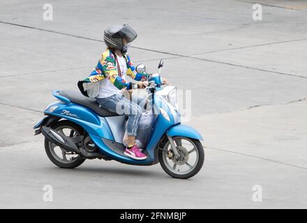 SAMUT PRAKAN, THAILAND, JULI 25 2020, EINE Frau mit Helm fährt ein Motorrad Stockfoto