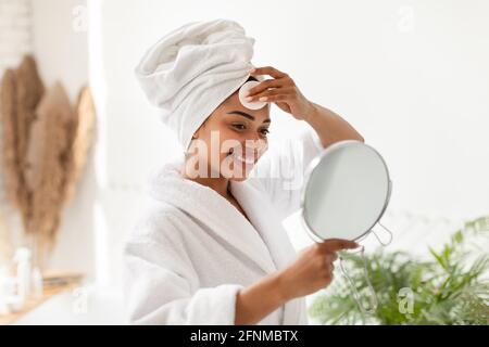Schwarze Frau Tut Gesichtshaut Routine Im Badezimmer Zu Hause Stockfoto