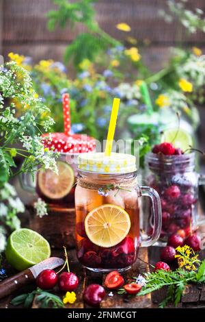 Gesunde hausgemachte kalte Limonade mit frischen Beeren und Früchten im Einmachglas Stockfoto