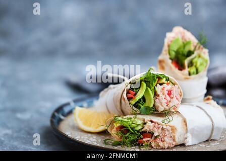 Frische und gesund verpackte Tortilla mit Krabbensalat, Gurke, Avocado, Pfeffer und grünen Kräutern Stockfoto