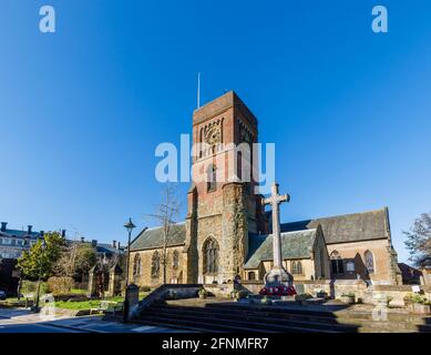 Pfarrkirche der Heiligen Jungfrau Maria, Diözese Chichester, und Steinkreuz-Kriegsdenkmal in Petworth, einer kleinen Stadt in West Sussex, Südostengland Stockfoto