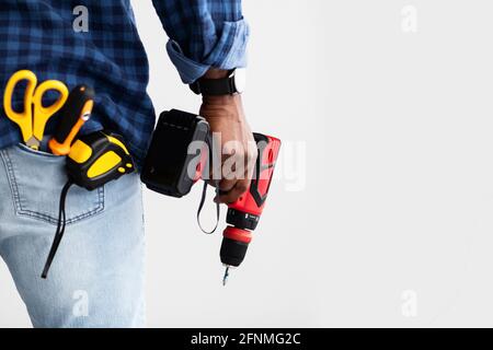 Männer arbeiten Konzept. Schwarzer Mann mit Schraubendreher, mit Werkzeugen in der Tasche, weißer Hintergrund mit freiem Platz, Rückansicht Stockfoto