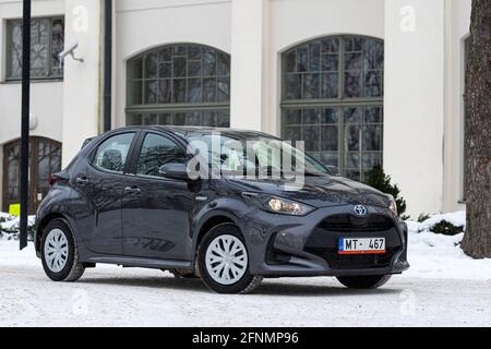 Riga, Lettland - 9. Februar 2021: Metallisch grauToyota Yaris Hybrid Y20 Edition Hatchback Auto in der Nähe des Wohnhauses geparkt Stockfoto