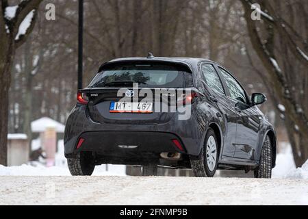 Riga, Lettland - 9. Februar 2021: Metallisch grauToyota Yaris Hybrid Y20 Edition Hatchback Auto in der Nähe des Wohnhauses geparkt Stockfoto