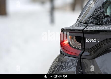 Riga, Lettland - 9. Februar 2021: Grau metallischer Toyota Yaris Hybrid Y20 Edition Hatchback, Nahaufnahme von Autoscheinwerfern Stockfoto