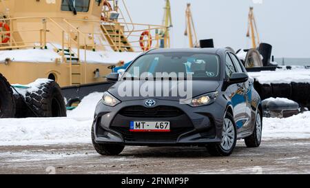 Riga, Lettland - 9. Februar 2021: Graumetallisches Toyota Yaris Hybrid Y20 Edition Auto auf einem industriellen Hintergrund Stockfoto