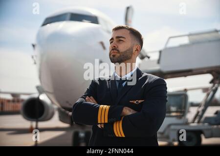Manly Captain überquert die Arme, während er auf Distanz schaut Stockfoto
