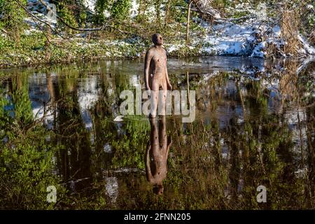 Nr. 2 von sechs lebensgroßen gusseisernen Skulpturen des Künstlers Antony Gormley mit dem Titel „6 Times“ on the Water of Leith in Edinburgh, Schottland, Großbritannien Stockfoto