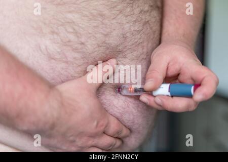 Fat Mann Hände machen Injektion mit Insulin-Stift oder Spritze, Medizin, Diabetes, Glykämie, Gesundheitsversorgung und Menschen Konzept. Stockfoto