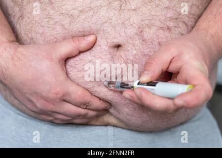 Fat Mann Hände machen Injektion mit Insulin-Stift oder Spritze, Medizin, Diabetes, Glykämie, Gesundheitsversorgung und Menschen Konzept. Stockfoto