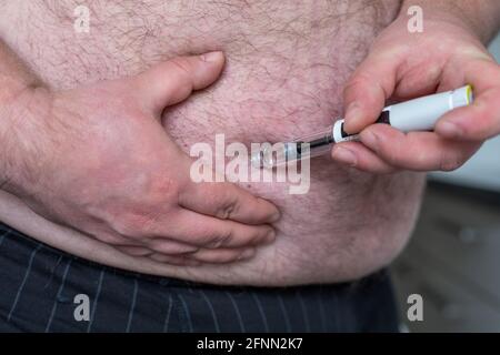 Fat Mann Hände machen Injektion mit Insulin-Stift oder Spritze, Medizin, Diabetes, Glykämie, Gesundheitsversorgung und Menschen Konzept. Stockfoto