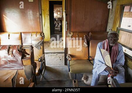 Mann, der im Personenwagen am Bahnhof in Bamako, Mali, Westafrika sitzt. Stockfoto